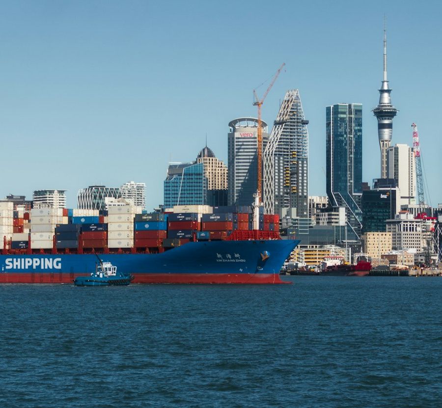 A container ship passing the Auckland skyline with the Sky Tower in view